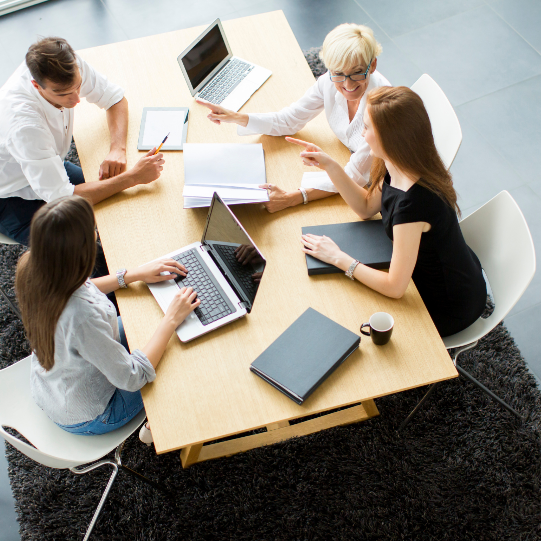 cuatro personas trabajando en una mesa